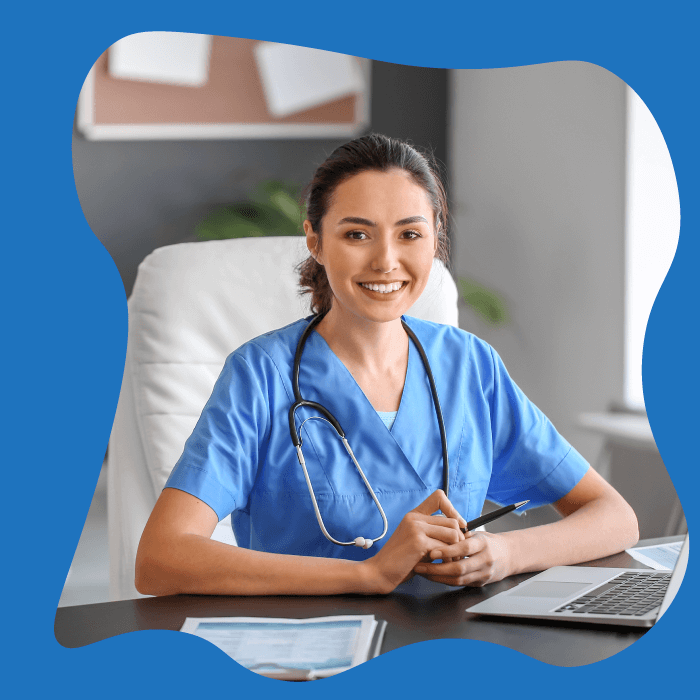 Female doctor sitting at her desk smiling at the camera