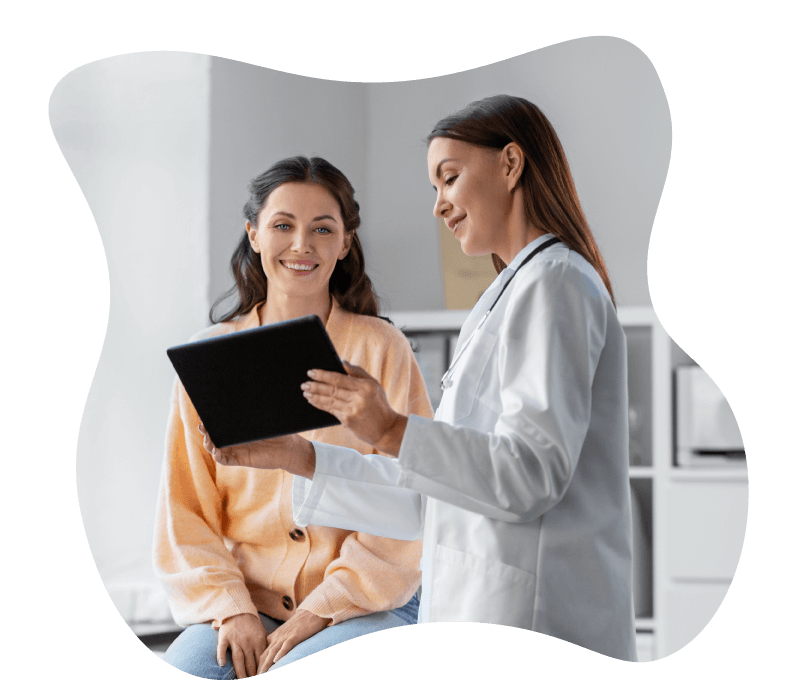 Female doctor showing information on a tablet to a female patient in a medical setting