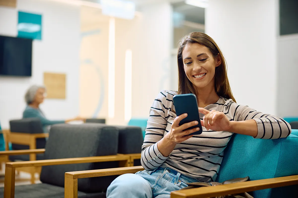 Patient using a smartphone for digital intake at a medical clinic